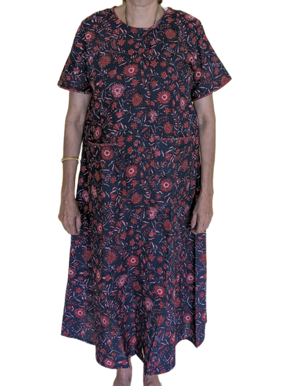 Person wearing a dark floral dress on a white background