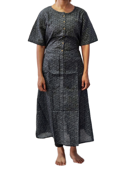 Person wearing a black patterned dress on a white background